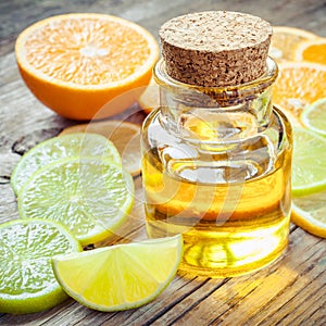 Citrus essential oil and slice of ripe fruits: orange, lemon and