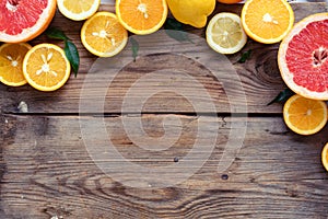 Citrus fresh summer fruits orange grapefruit lemon on brown wooden background