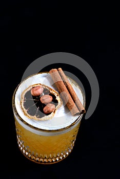 citrus fruit alcoholic iced drink fruit juice with cinnamon isolated on black background