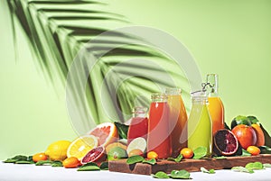 Citrus fruit juices, fresh and smoothies, food background. Summer drinks. Mix of different whole and cut fruits: orange,