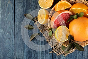 Citrus fruit. various citrus fruits with leaves of lemon, orange, grapefruit in a basket and orange juice on a blue wooden table.