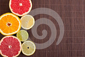 Citrus fruits cut background- oranges, lemons, limes, grapefruit on a wooden background