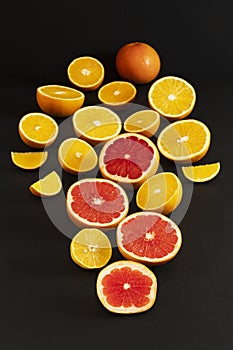 Citrus fruits cut into slices laid out in the form of a heart on a black background