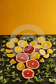 Citrus fruits cut into slices laid out in the form of a heart on a black background