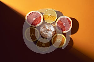 Citrus fruits and glass with ice in sunlight. Making cold drink