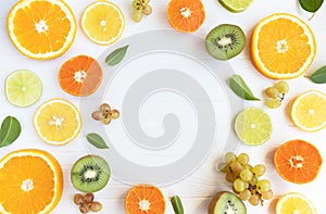 Citrus fruits and kiwi cut into circles, grapes on a white background with space for text. Poster, banner, article