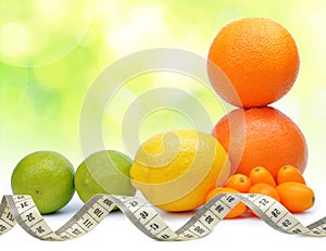 Citrus fruits Orange, Grapefruit, Lemon, Lime, Kumquat with measuring tape.