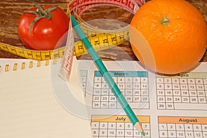 Citrus fruits, tomato. Measure tape and fresh fruit in the background. Healthy lifestyle diet with fresh fruits