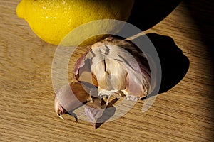 Citrus lemon and garlic fresh and healthy food products laying on wooden chop board ready to cook - food image close up with creat