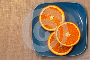 Citrus. A mandarin is served on a blue plate.