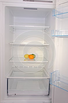 Citrus in open empty refrigerator.