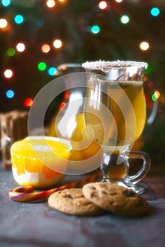 Citrus punch in the glass on the dark table with Christmas decorations