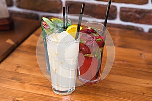 Citrus and raspberry lemonades, PiÃ±a colada on a wooden table in a cafe.