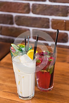 Citrus and raspberry lemonades, PiÃ±a colada on a wooden table in a cafe.