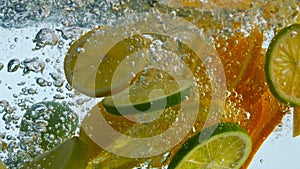 Citrus slices bubbling water in super slow motion closeup. Mix orange with lemon