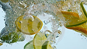 Citrus slices bubbling water in super slow motion closeup. Mix orange with lemon