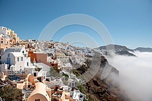 City above the clouds. Views of Oia village, Santorini island, Greece.