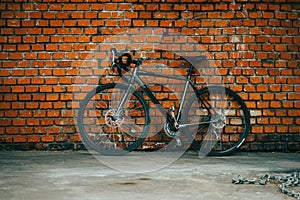 City bicycle stading againist the background of red brick wall.