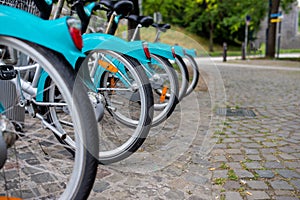 City bikes rent parking in Belgium. Standing at the stone road.