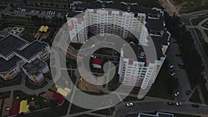 City block. Modern multi-storey buildings. Flying at dusk at sunset. Aerial photography.