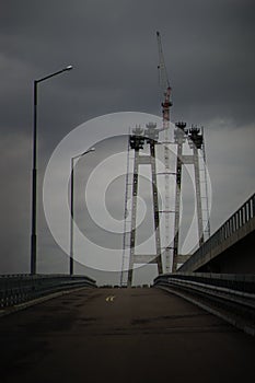 City bridge construction with road, lanterns and crane