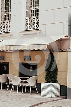 City cafe exterior. White tables and chairs outdoors in summer