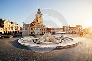 City central square (Piata Sfatului) with town council hall tower, fountain morning sunrise view, location Brasov, Transylvania,