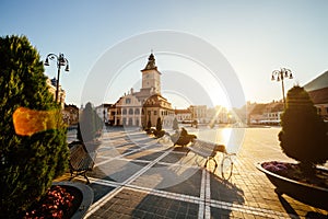 City central square (Piata Sfatului) with town council hall tower morning sunrise view, location Brasov, Transylvania, Romania.