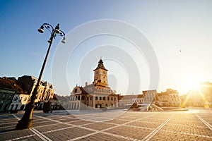 City central square (Piata Sfatului) with town council hall tower morning sunrise view, location Brasov, Transylvania, Romania.