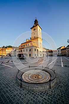 City central square (Piata Sfatului) with town council hall tower morning sunrise view, location Brasov, Transylvania, Romania.