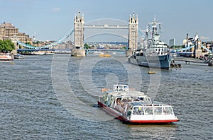 A City Cruises tour boat sails on the Thames River near Tower bridge