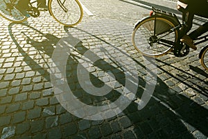 City cyclists, people riding bicycles on cobblestone road