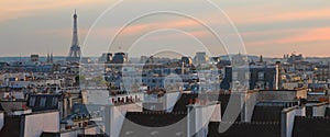 Panorama cityscape of Parisian rooftops and Eiffel Tower. Famous landmark, icon, tourist destination in Paris, France.