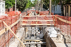 City district heating pipeline reparation and reconstruction parallel with the street with orange construction safety net or barri