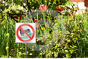 city flower bed with a sign forbidding trampling on flowers.