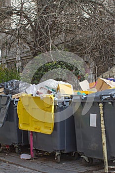 city garbage containers overflowing with plastics, cardboard, food and overconsumption