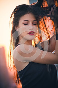 City girl portrait at top of building at sunset