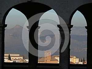 The city of Granada framed by the arches of a portico