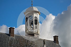 City hall chime and clock against blue sky, dark clouds approaching