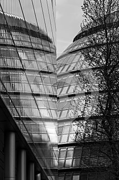 City Hall, London taken from the rear at sun down. Building is reflected in the glass facade of the adjacent building.