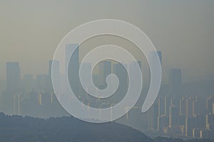 City high-rises and buildings in the early morning fog in the distance