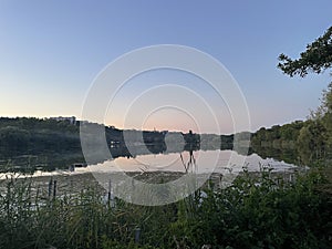 City lake at the summer evening. REflections on the water. wide shot, perspective