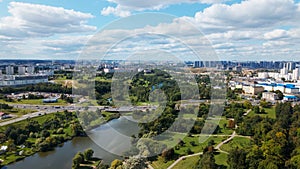 City landscape. Nearby there is a park area. Blue sky with white clouds. Aerial photography