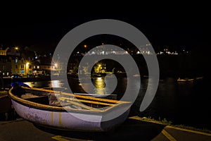 City landscape,of Portree at night with the lights of lamppost reflected on the sea water, Isle of Skye, United Kingdom