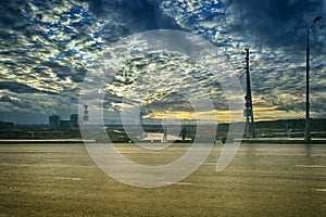 City landscape with smoke, sky and clouds. Sunset on the background of construction. Post-Apocalypse in real life . Blocked road,