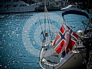 City landscape on a sunny day with Flag of Norway on a yacht