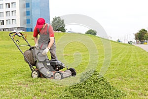 City landscaper unloading grass from lawn cutter bag