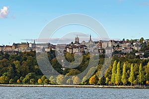 The city of Lausanne emerges above the lake geneva shoreline in autumn