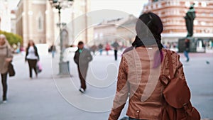 City lifestyle. Stylish hipster woman tourist walking on old town street. Pretty girl rear view enjoying spring outdoors