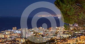 City lights of Cape Town at sunset from above with copy space. Panoramic coastal urban landscape at night. High angle